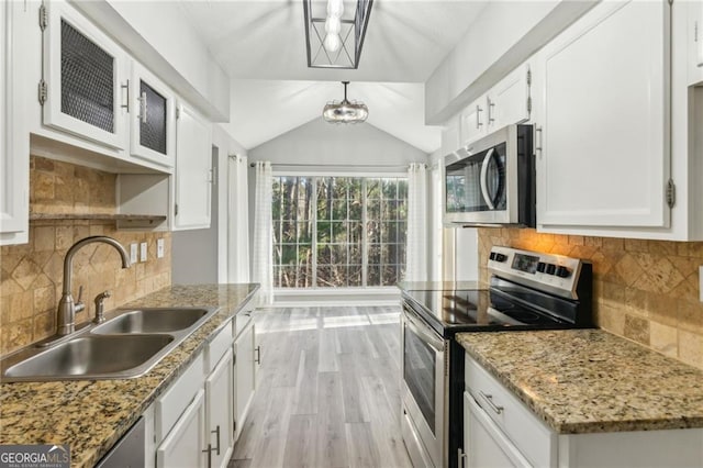 kitchen featuring appliances with stainless steel finishes, light stone countertops, sink, and white cabinets