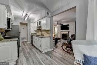 kitchen featuring sink, white cabinets, ceiling fan, and light hardwood / wood-style flooring