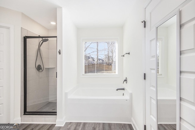 bathroom with plus walk in shower and hardwood / wood-style floors