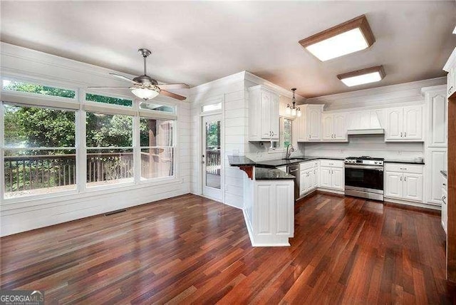 kitchen featuring white cabinetry, decorative light fixtures, dark hardwood / wood-style floors, and appliances with stainless steel finishes