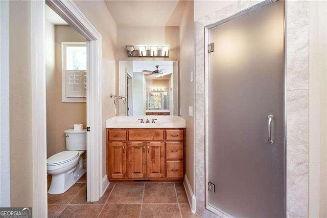 bathroom with an enclosed shower, vanity, tile patterned flooring, and toilet