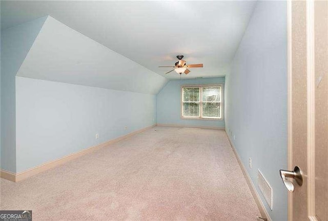 bonus room with vaulted ceiling, light colored carpet, and ceiling fan