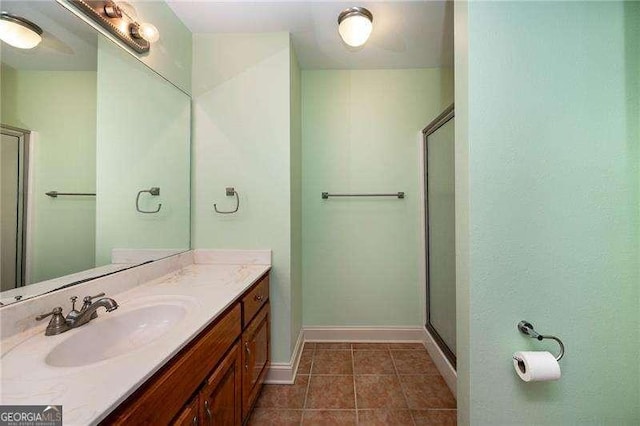 bathroom with vanity, tile patterned floors, and a shower with door