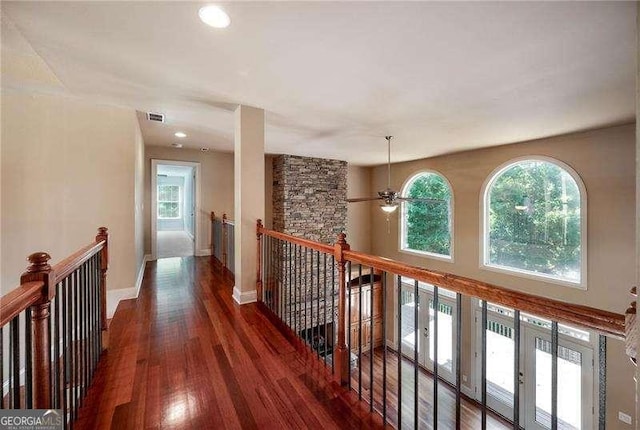 corridor with a healthy amount of sunlight and dark hardwood / wood-style flooring