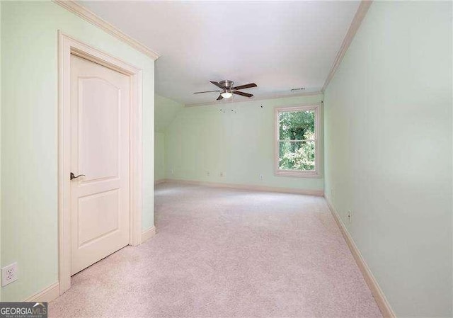 unfurnished room with crown molding, light colored carpet, and ceiling fan