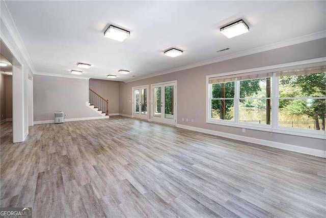 unfurnished living room with ornamental molding, a healthy amount of sunlight, and light wood-type flooring