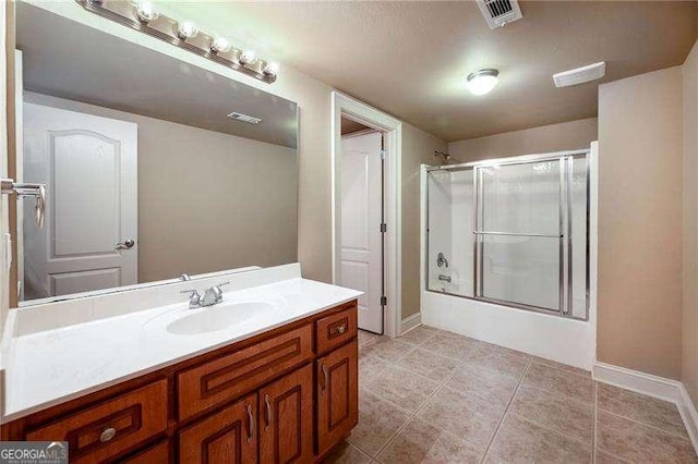 bathroom featuring tile patterned floors, vanity, and combined bath / shower with glass door