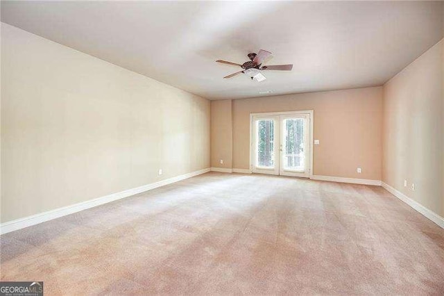 unfurnished room featuring french doors, light colored carpet, and ceiling fan