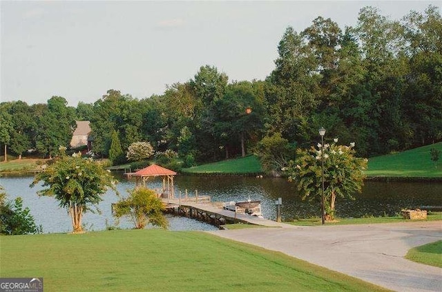 surrounding community featuring a water view and a lawn