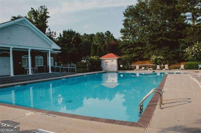 view of swimming pool with an outdoor structure and a patio area