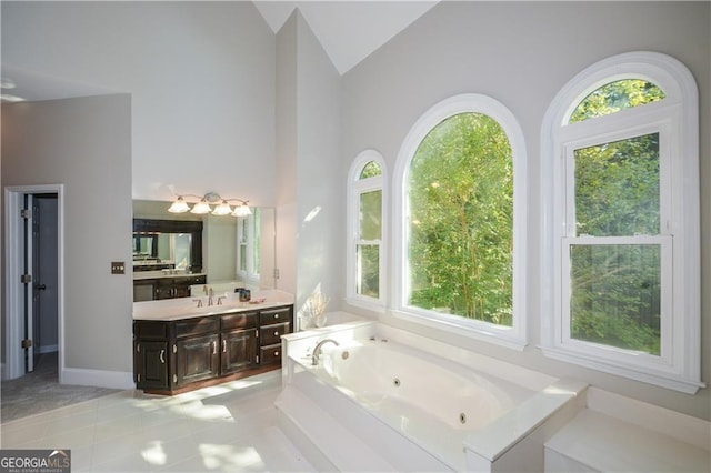 bathroom featuring vanity, a washtub, a wealth of natural light, and high vaulted ceiling