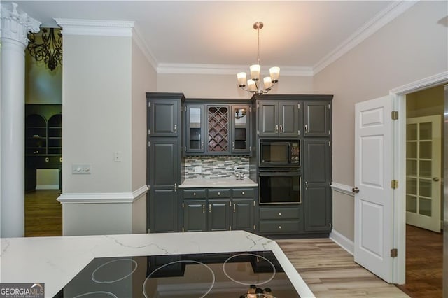 kitchen with decorative light fixtures, a kitchen breakfast bar, light hardwood / wood-style floors, black appliances, and crown molding