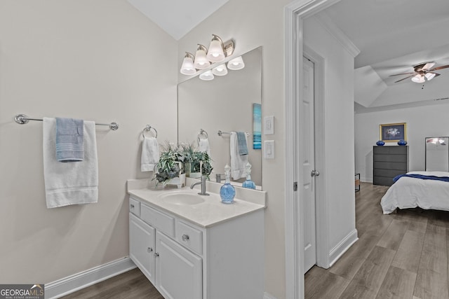 bathroom with vanity, vaulted ceiling, hardwood / wood-style floors, and ceiling fan