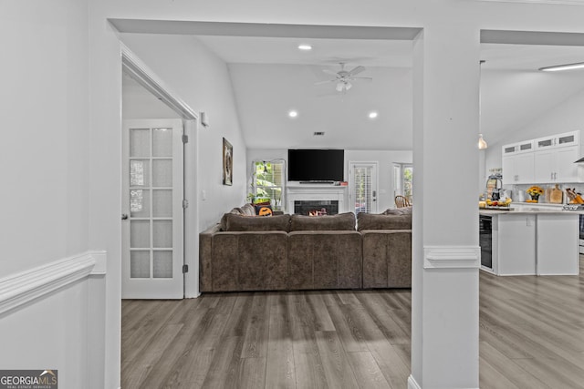 living room featuring vaulted ceiling, wine cooler, ceiling fan, and light hardwood / wood-style floors