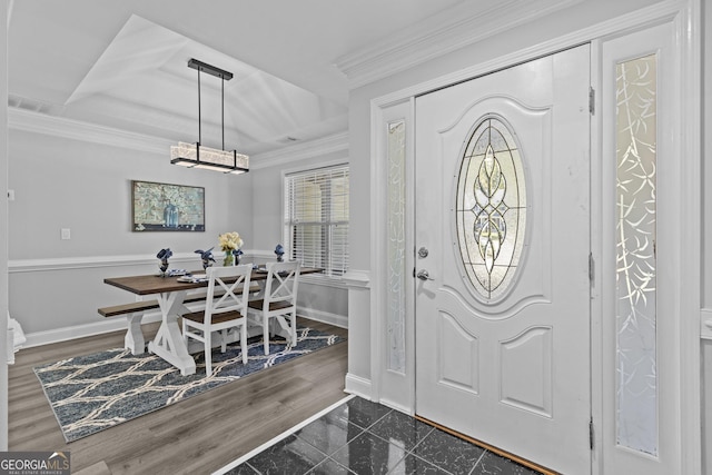 foyer with ornamental molding and dark hardwood / wood-style floors