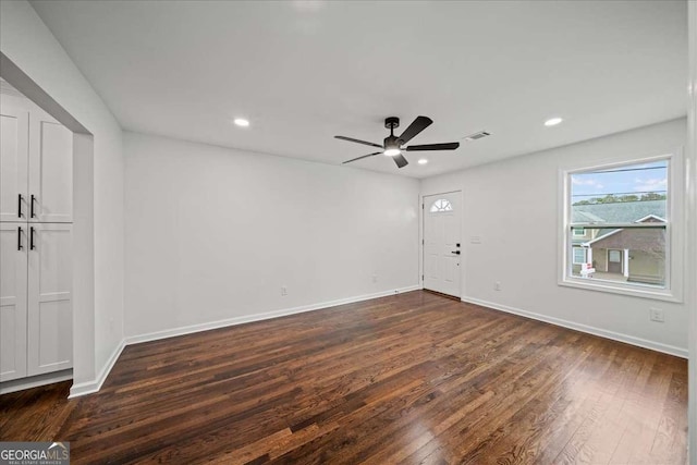 empty room with ceiling fan and dark hardwood / wood-style flooring