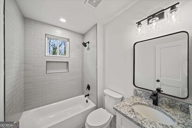 full bathroom with vanity, tiled shower / bath combo, and toilet