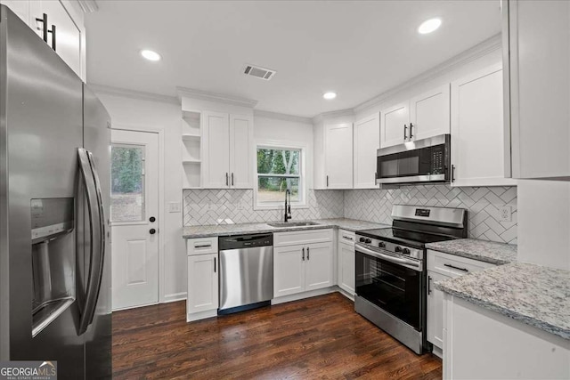 kitchen featuring sink, dark hardwood / wood-style floors, stainless steel appliances, light stone countertops, and white cabinets