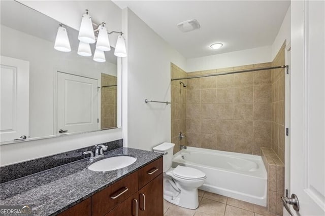 full bathroom featuring vanity, tiled shower / bath, tile patterned floors, and toilet