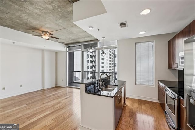 kitchen featuring sink, light hardwood / wood-style flooring, pendant lighting, ceiling fan, and stainless steel appliances