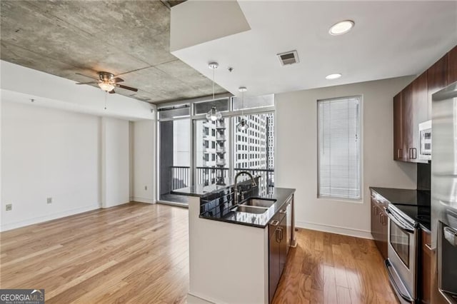 44 Peachtree Pl NW Unit 1828, Atlanta, GA 30309 - kitchen with stainless steel appliances, dark countertops, light wood-style floors, a sink, and baseboards