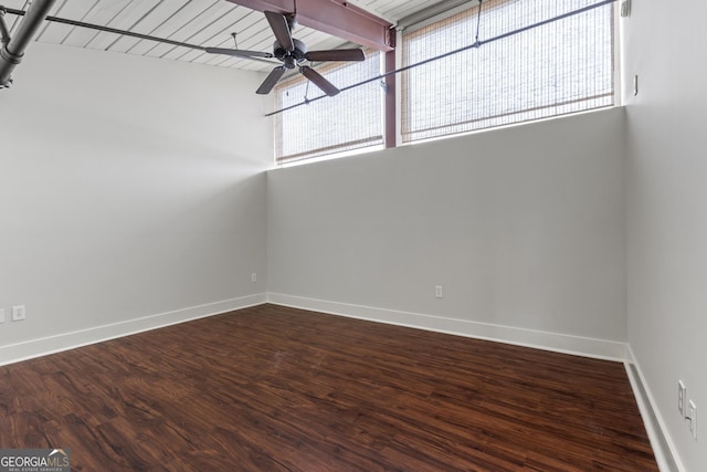 spare room with dark wood-type flooring, beamed ceiling, and ceiling fan