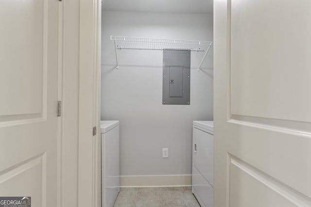 laundry area featuring washing machine and clothes dryer, light tile patterned floors, and electric panel