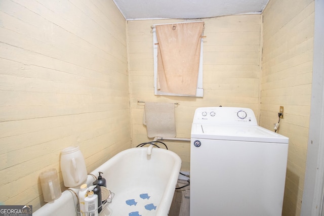 washroom with washer / dryer and wood walls