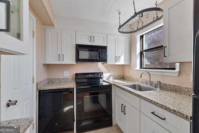 kitchen featuring white cabinetry, sink, light tile patterned floors, and black appliances