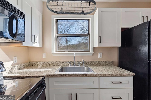 kitchen with sink, white cabinets, and black appliances