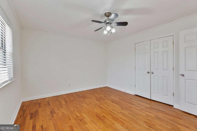 unfurnished bedroom featuring multiple windows, ornamental molding, and light hardwood / wood-style flooring