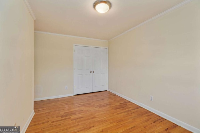 unfurnished bedroom with ornamental molding, light hardwood / wood-style floors, and a closet