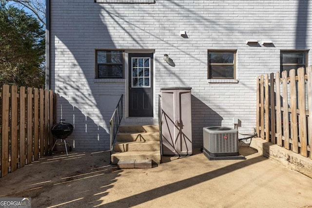 rear view of property featuring a patio and central air condition unit