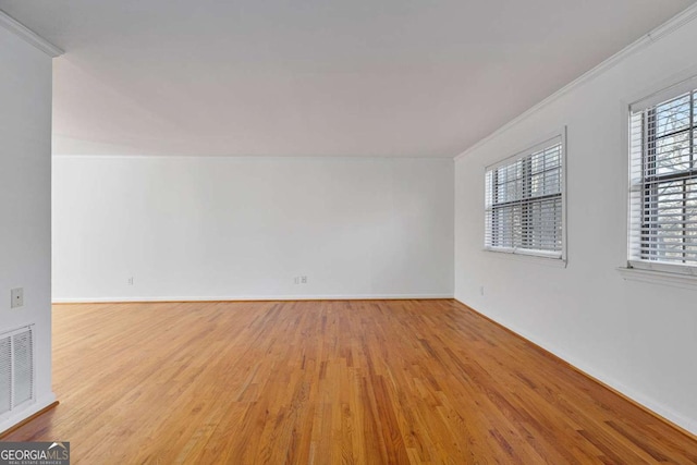 spare room with ornamental molding and light hardwood / wood-style floors