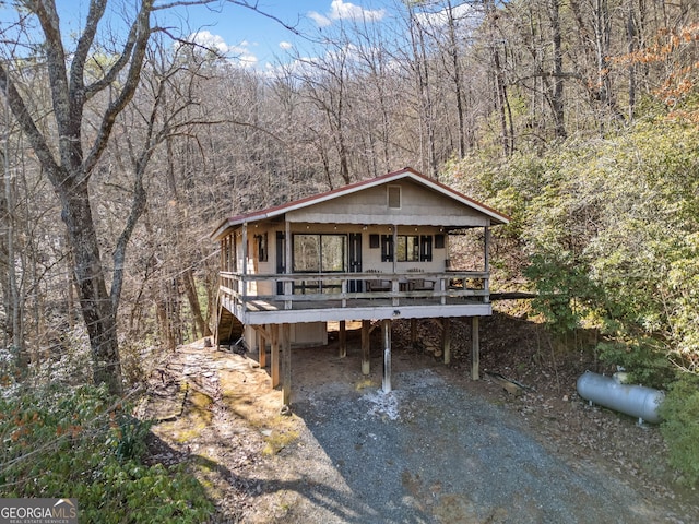 view of front of property featuring a wooden deck, a carport, and a porch