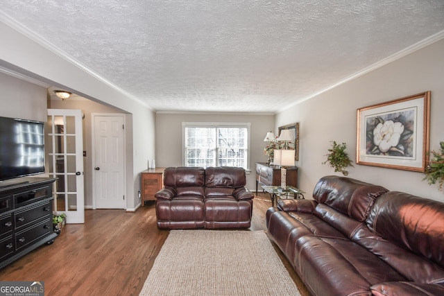 living area with ornamental molding, french doors, a textured ceiling, and wood finished floors