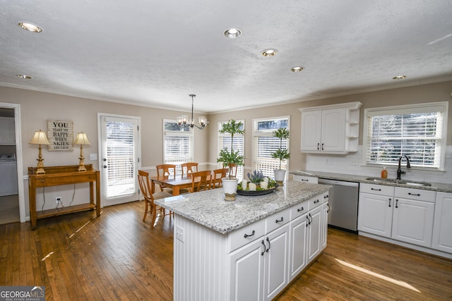 kitchen featuring plenty of natural light, dark wood finished floors, dishwasher, white cabinetry, and a sink