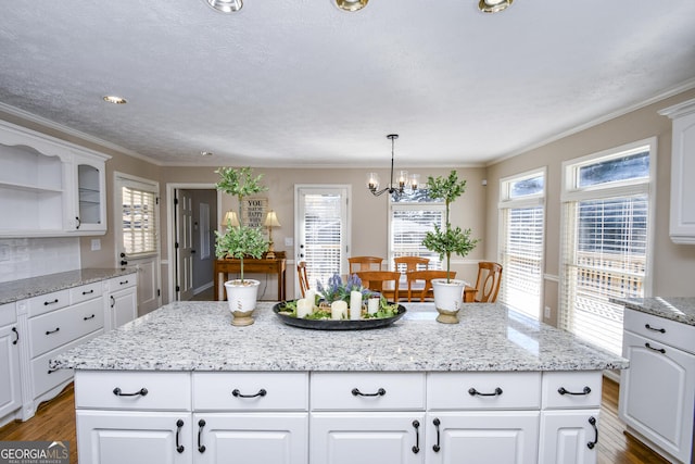 kitchen with white cabinetry, open shelves, wood finished floors, and a center island