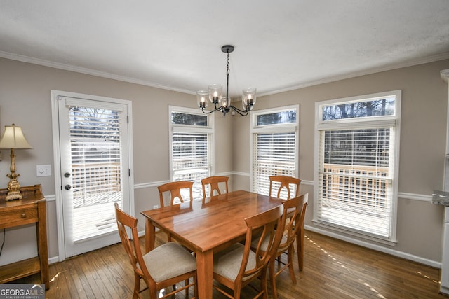 dining room featuring baseboards, a notable chandelier, crown molding, and hardwood / wood-style floors