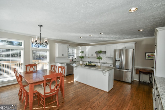 kitchen with dark wood-type flooring, a kitchen island, stainless steel appliances, and a sink