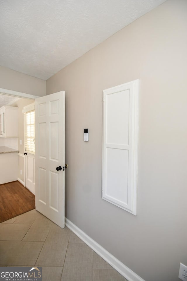 interior space with a textured ceiling and baseboards