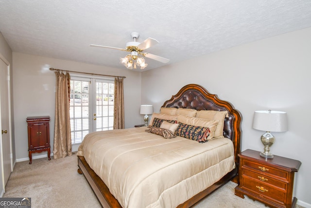 bedroom with access to exterior, a textured ceiling, french doors, and light colored carpet