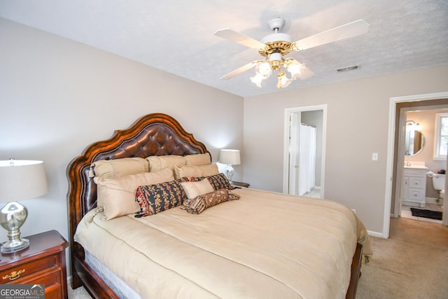 bedroom with a textured ceiling, ceiling fan, carpet flooring, visible vents, and baseboards