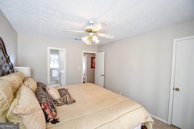 bedroom with a textured ceiling, ceiling fan, visible vents, carpet, and ensuite bath