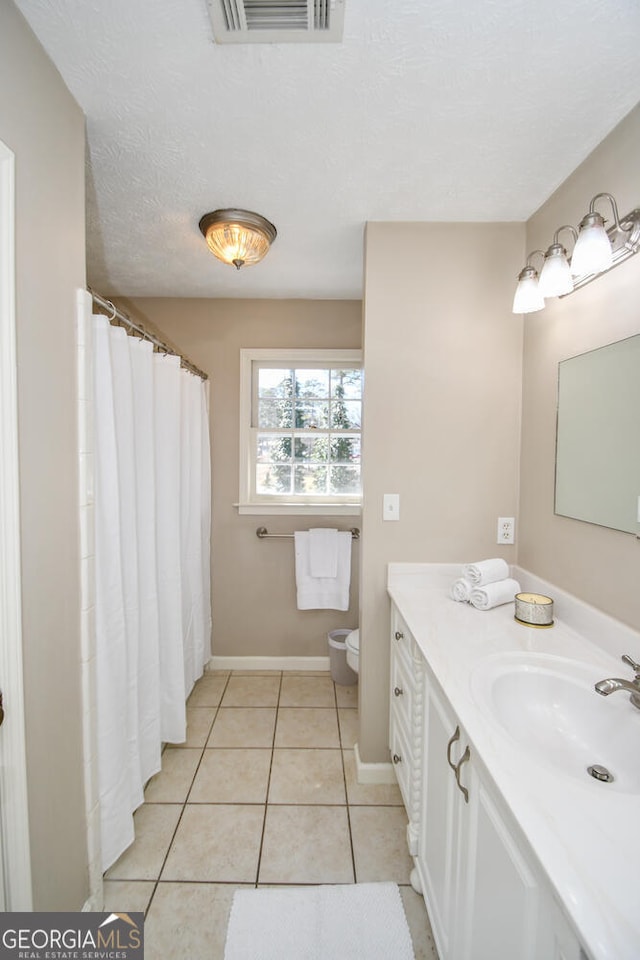 full bathroom with visible vents, toilet, tile patterned flooring, a textured ceiling, and vanity