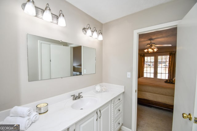 ensuite bathroom with baseboards, ensuite bathroom, a ceiling fan, and vanity