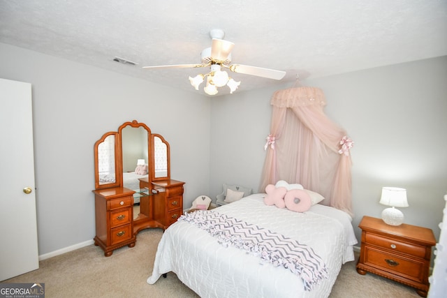 carpeted bedroom featuring ceiling fan, a textured ceiling, and visible vents