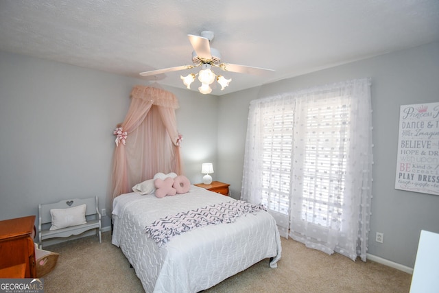 carpeted bedroom with a ceiling fan and baseboards