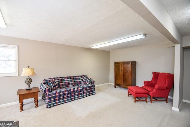 carpeted living room featuring a textured ceiling and baseboards