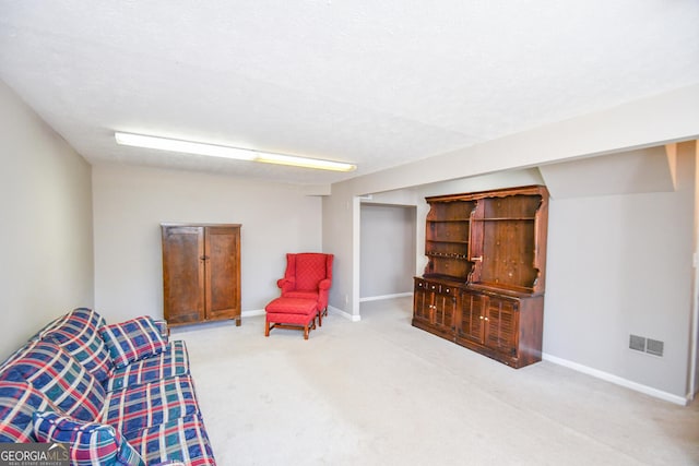 sitting room with a textured ceiling, carpet flooring, visible vents, and baseboards